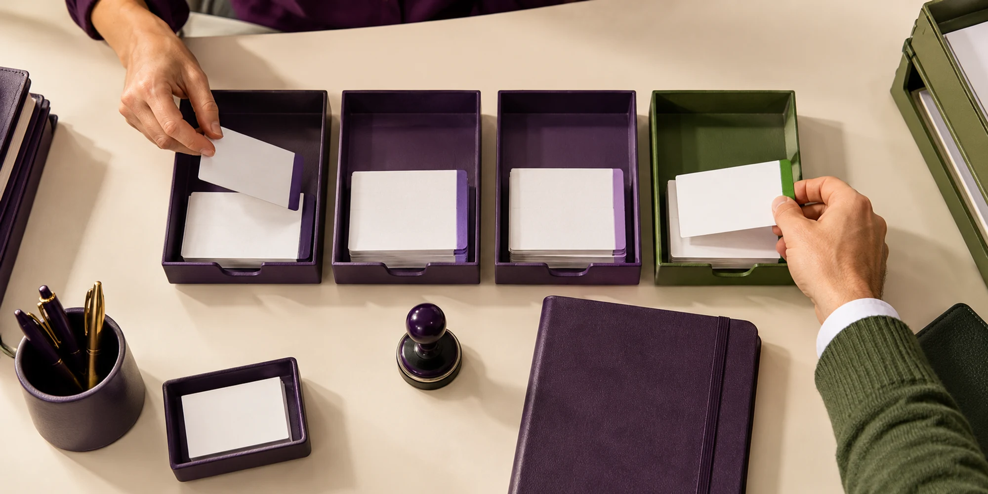 Two clinic administrators sort blank appointment cards across four separate trays
